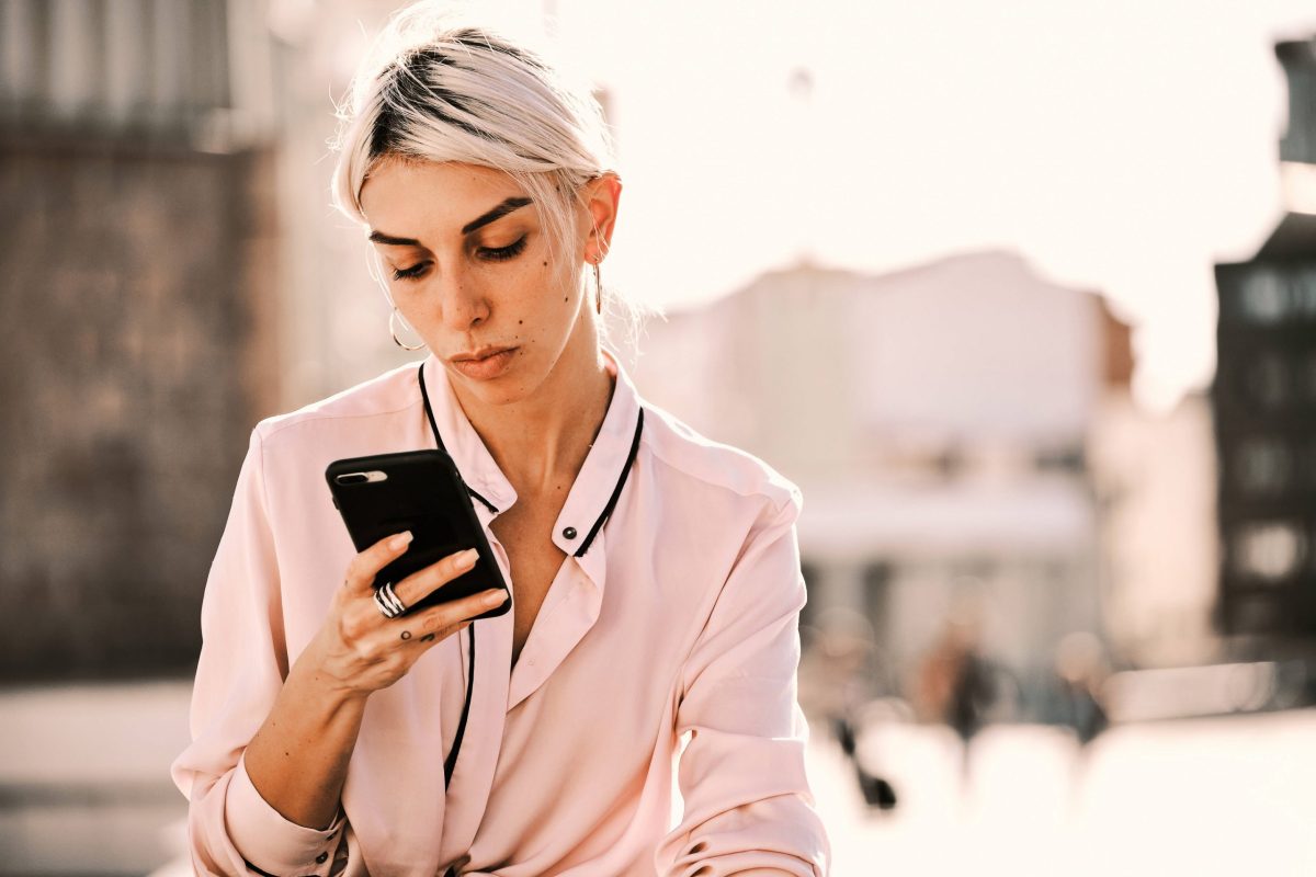 Symbolbild einer aufs Smartphone schauenden Frau