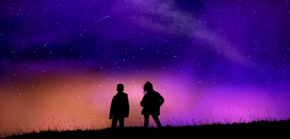 Zwei Personen beobachten Sterne am Himmel.