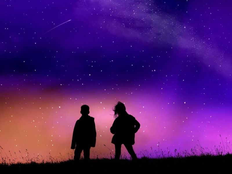 Zwei Personen beobachten Sterne am Himmel.