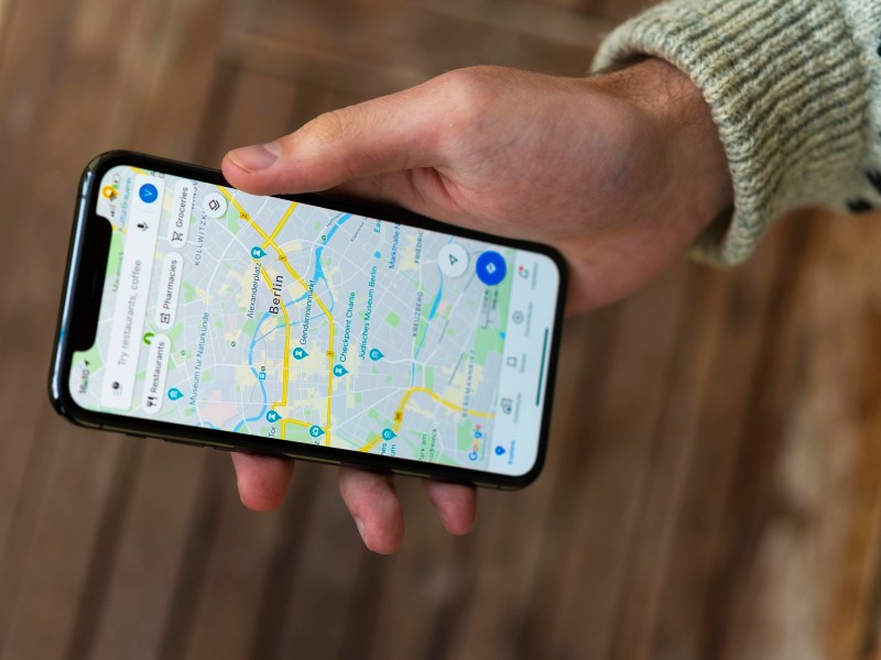 Hand hält Telefon, auf der die Google Maps-App aktiviert ist