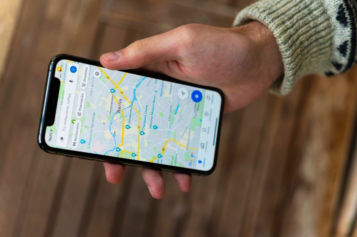 Hand hält Telefon, auf der die Google Maps-App aktiviert ist