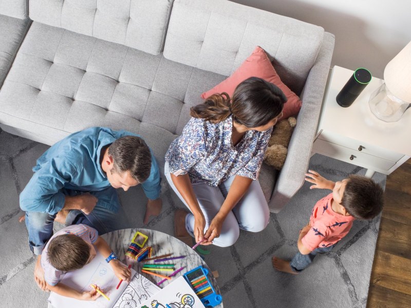 Eine Familie vor einem Echo-Lautsprecher von Amazon.