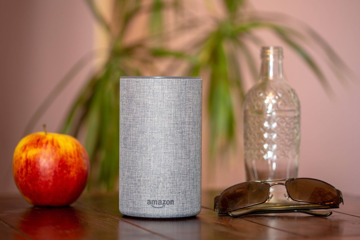 Amazons Echo-Lautsprecher neben einer Glasflasche und einem Apfel auf einem Tisch