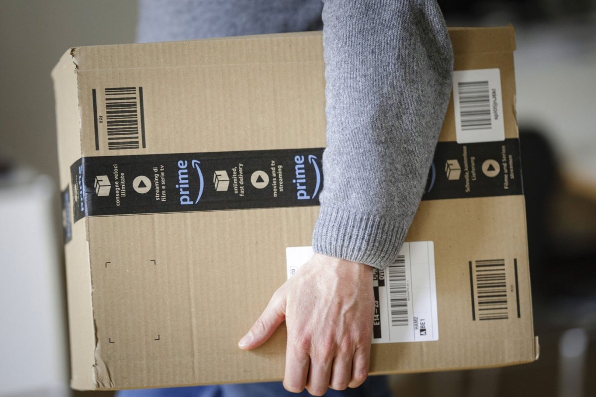 Mann mit Amazon-Paket unter dem Arm