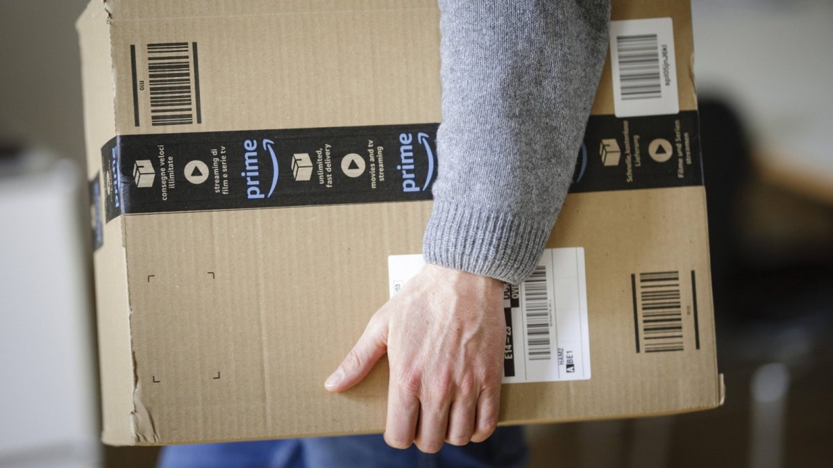 Mann mit Amazon Prime Paket in der Hand.