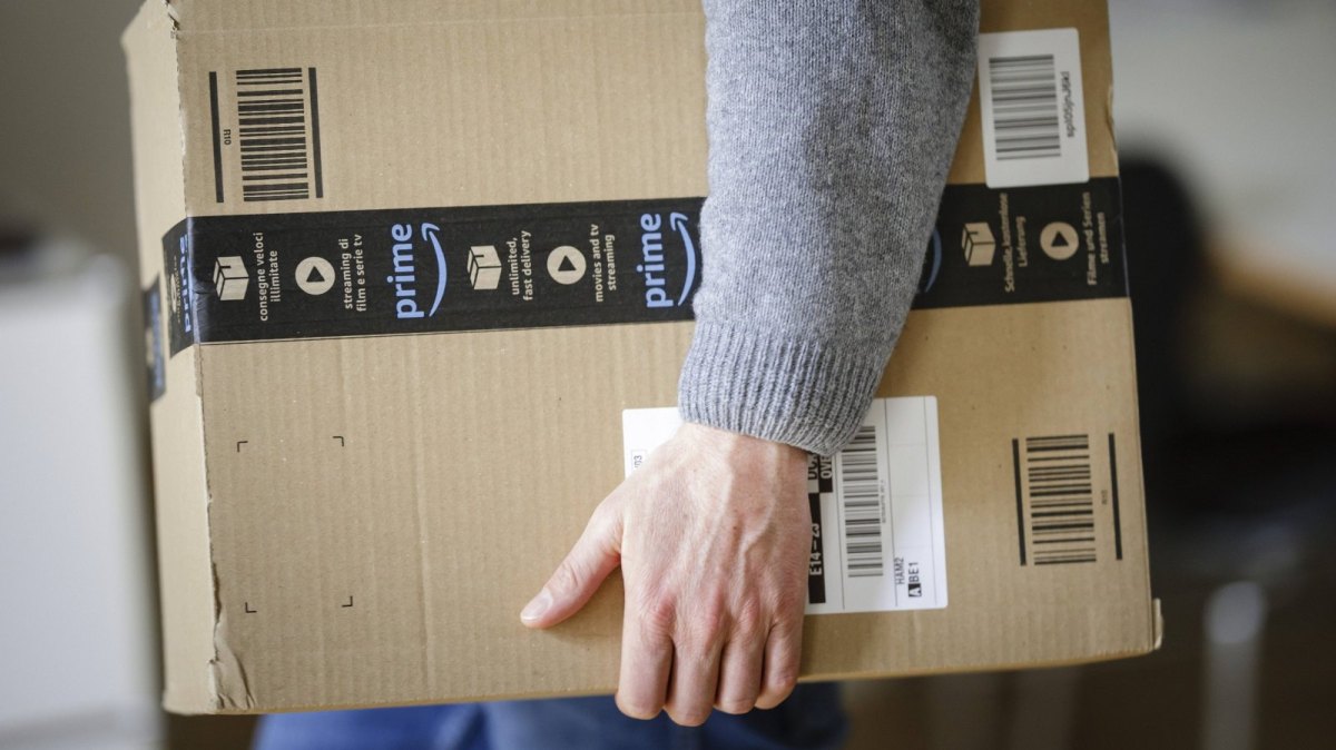 Mann mit Amazon Prime Paket in der Hand.