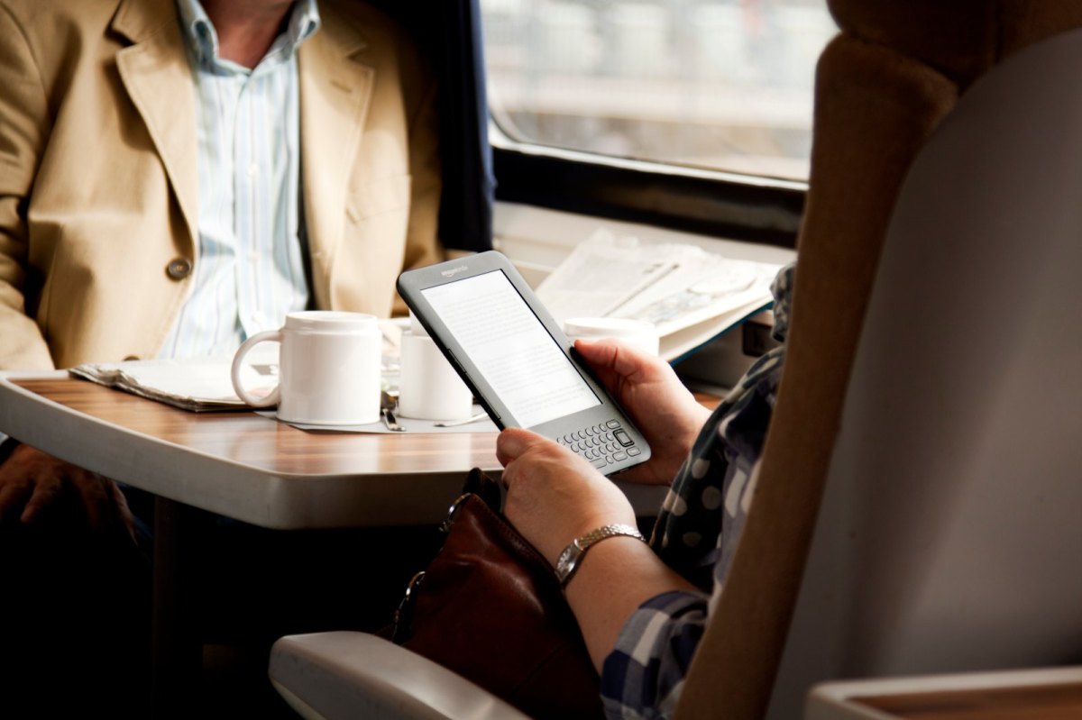 Mensch im Zug mit Amazon Kindle