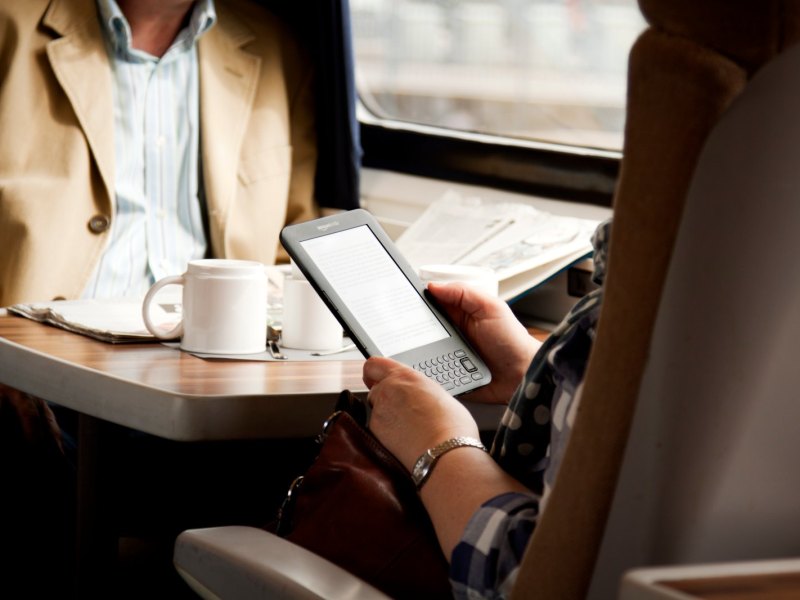Mensch im Zug mit Amazon Kindle