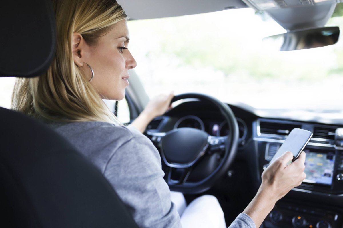 Frau mit Handy im Auto