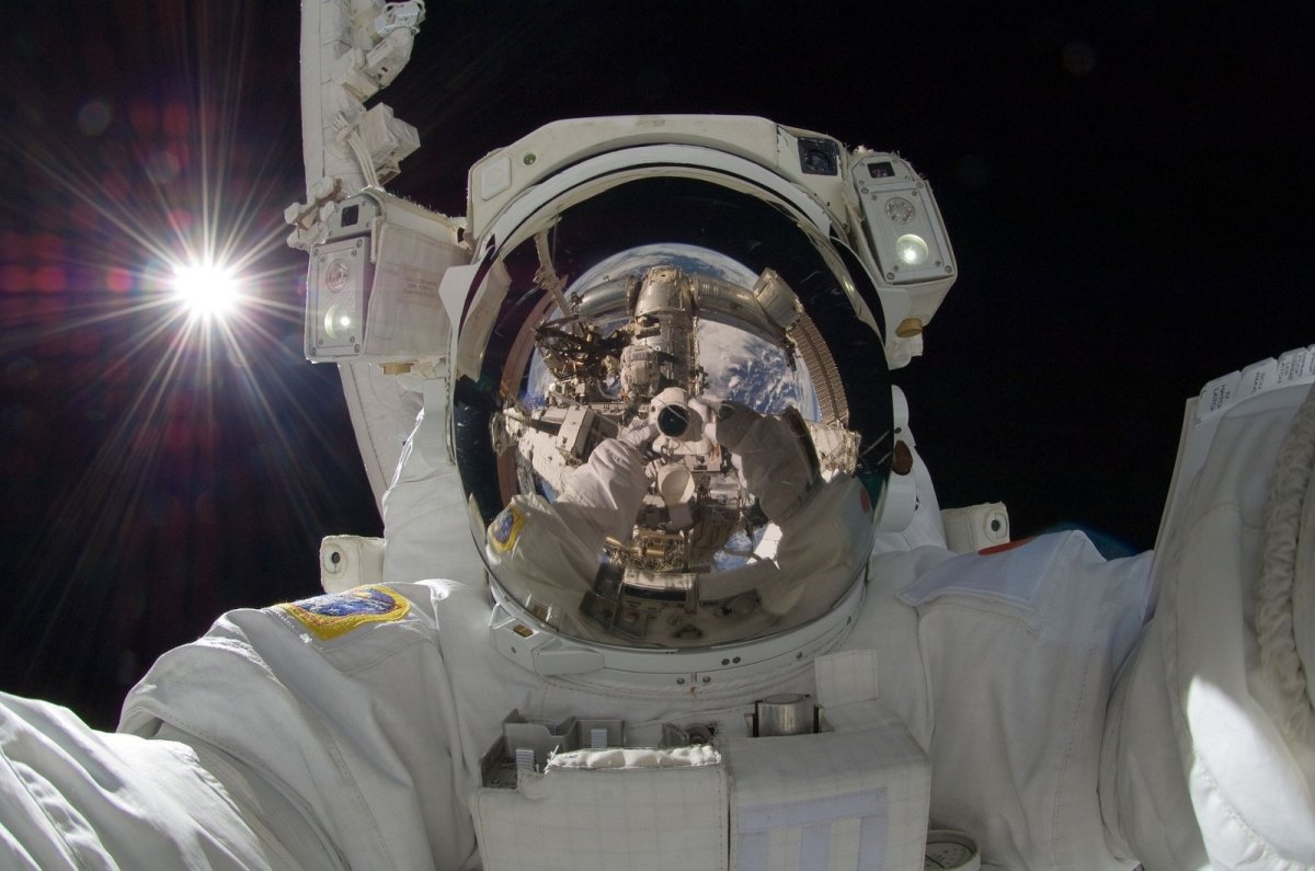 Ein Astronaut im Weltall schaut in die Kamera.