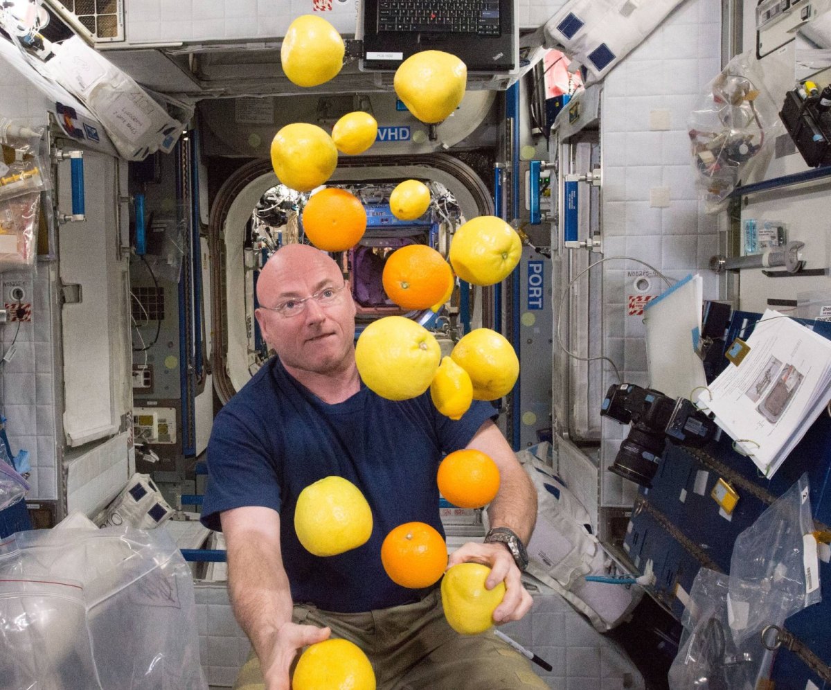 Astronaut in Weltraumkapsel mit Zitronen in der Schwerelosigkeit