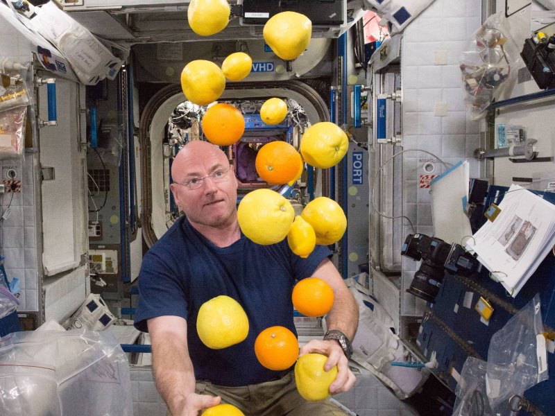 Astronaut in Weltraumkapsel mit Zitronen in der Schwerelosigkeit