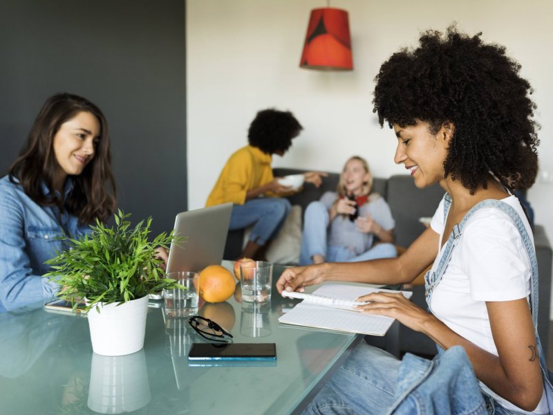 Zwei Frauen sitzen in einem modernen Büro an einem Tisch