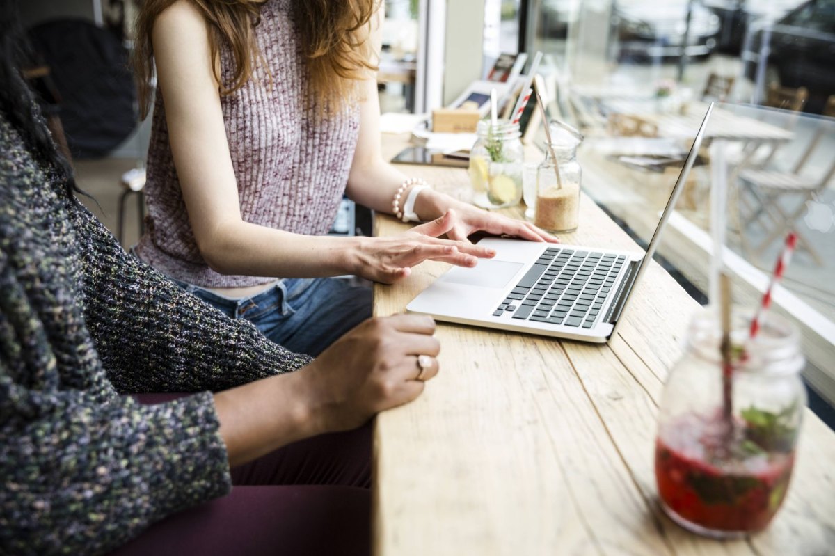Zwei Frauen surfen im Café auf ihren Laptops im Internet.