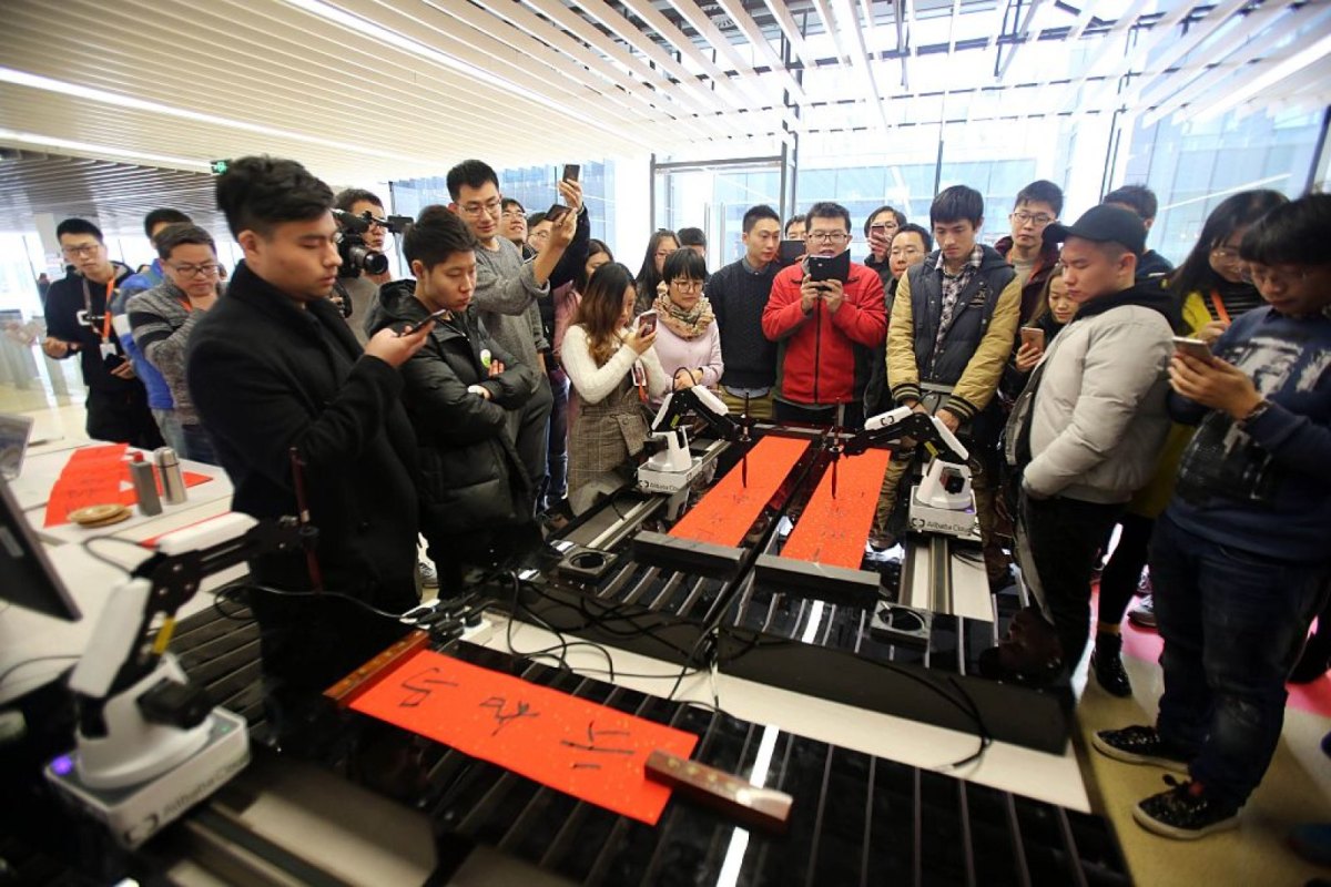 Alibaba-Mitarbeiter beobachten einen schreibenden Roboter