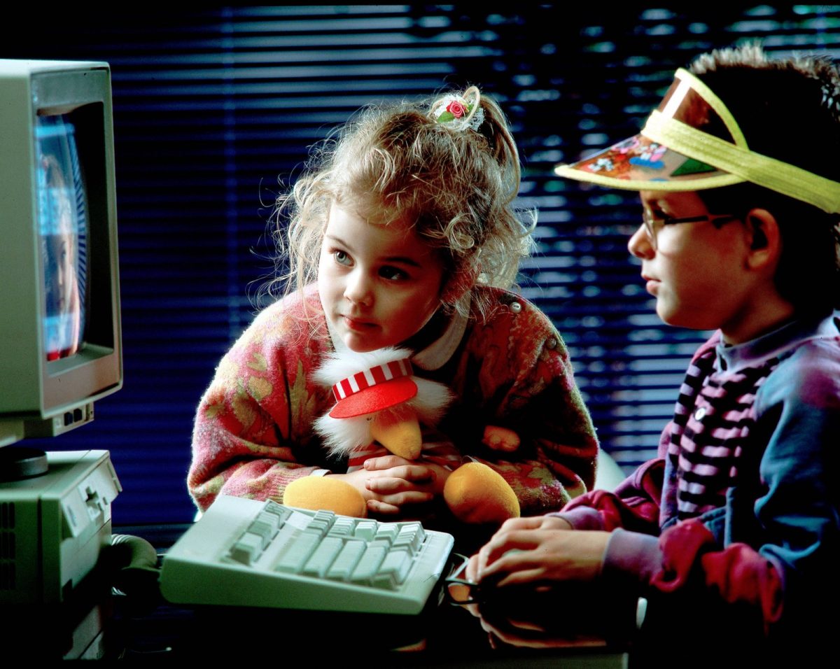 Mädchen und Junge sitzen gebannt am Computer.