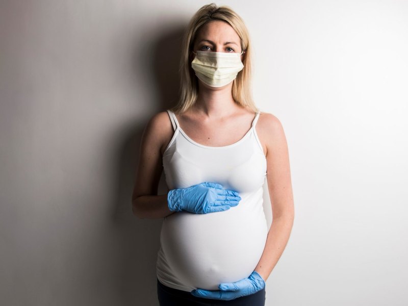 Schwangere mit Gesichtsmaske.