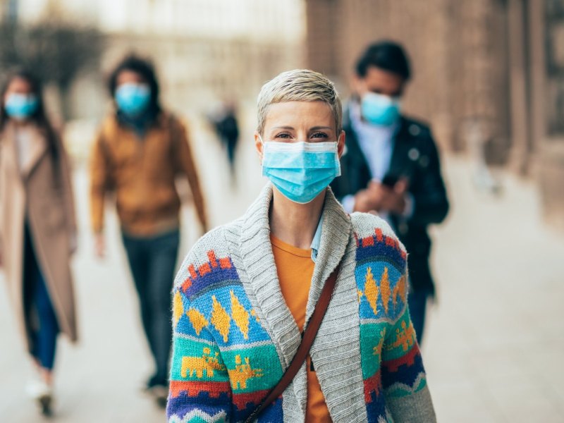 Frau mit Mundschutz auf der Straße.