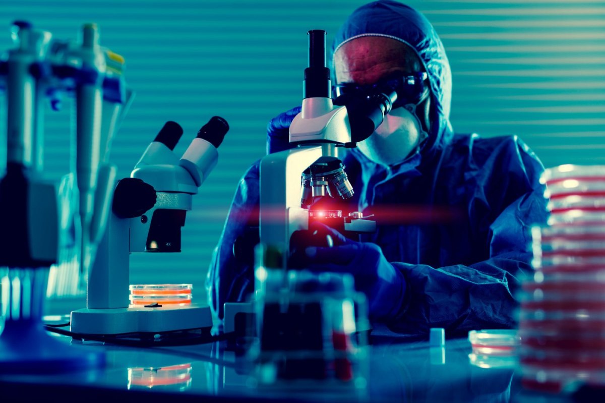 Mann im Labor mit Mikroskop.