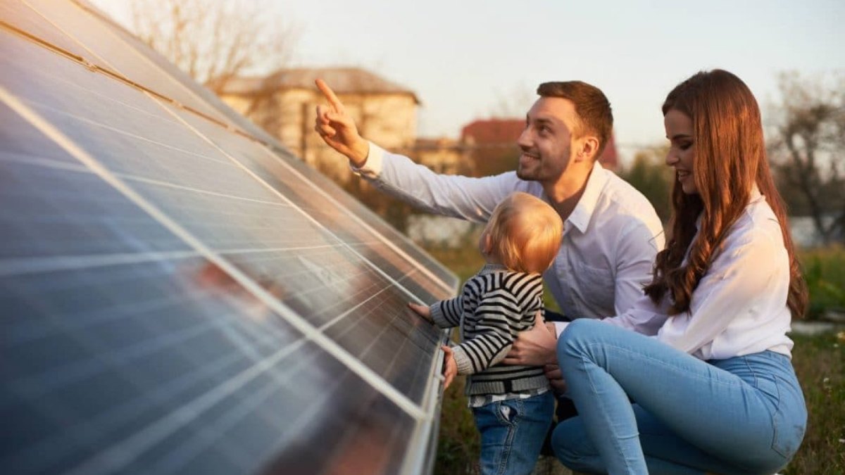 Junge Familie blickt auf Solaranlage