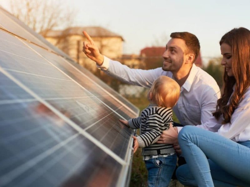 Junge Familie blickt auf Solaranlage