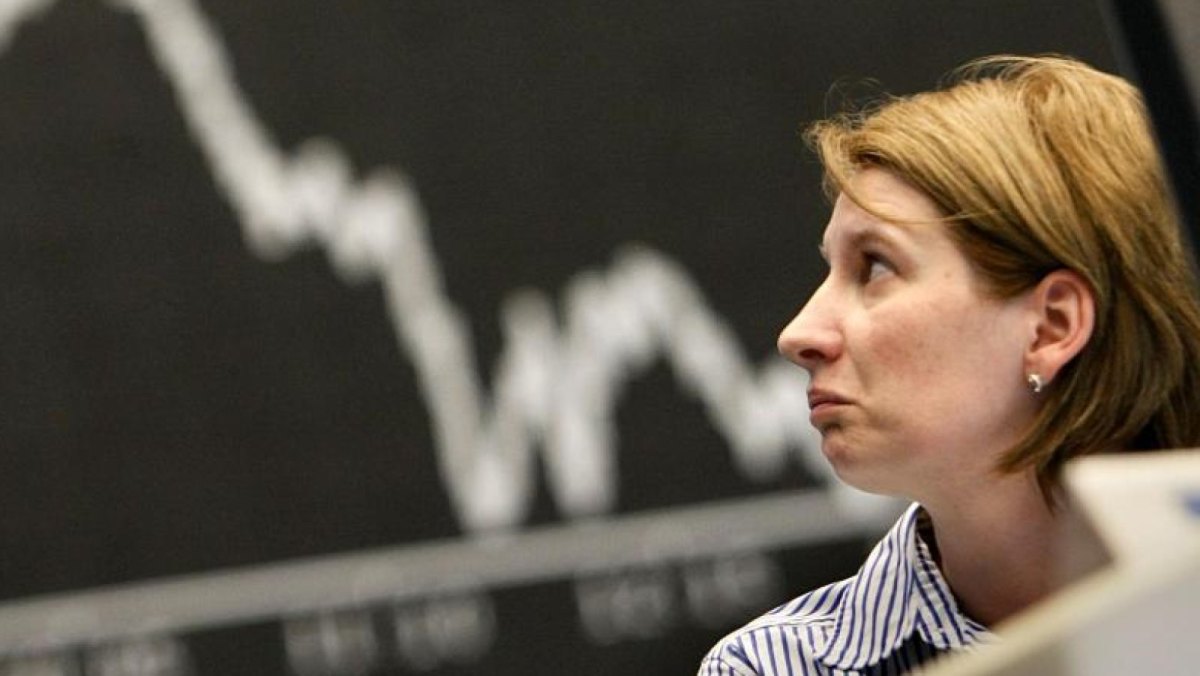 Eine Brokerin schaut in der Börse in Richtung des Dax-Index.
