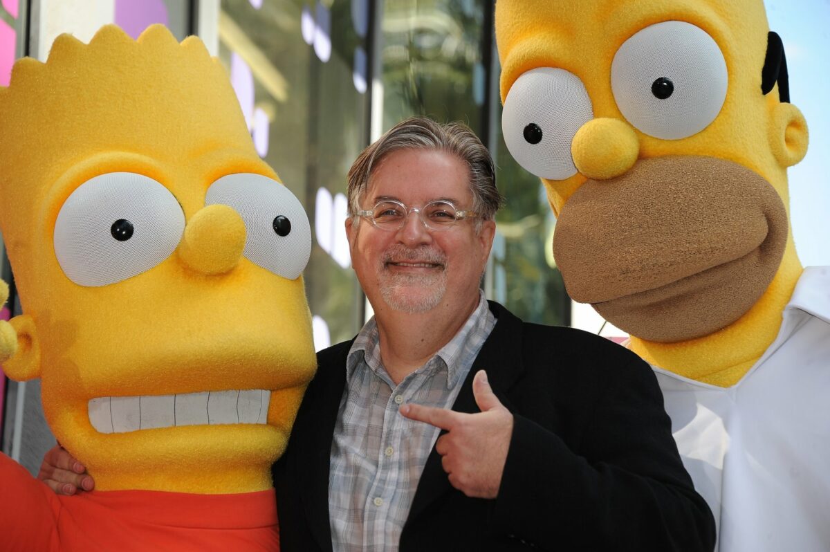 Zwei als Homer und Bart kostümierte Personen mit Simpsons-Erfinder Matt Groening in der MItte