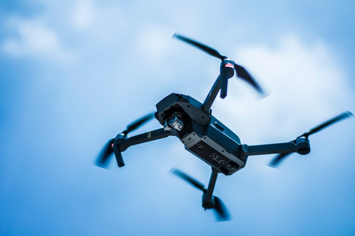 Eine Drohne fliegt vor blauem Himmel.