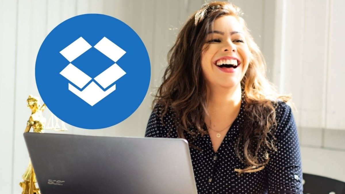 Eine Frau sitzt am Laptop und lacht. Im Vordergrund ist das Dropbox-Logo.