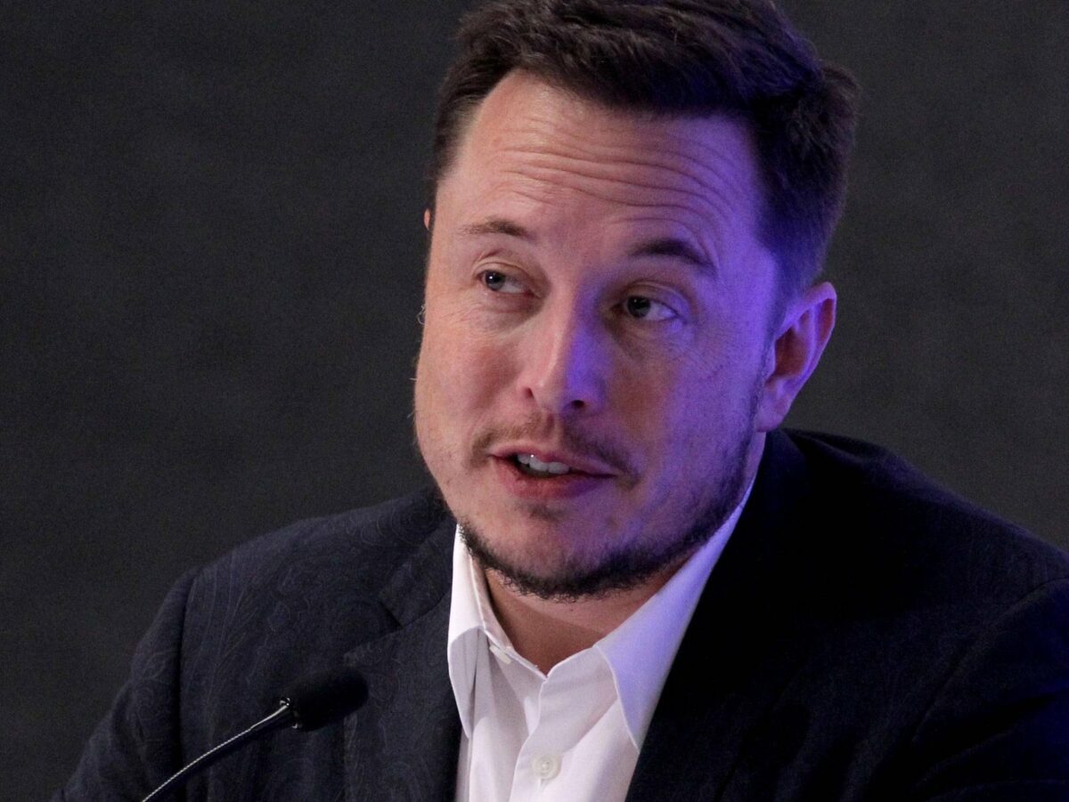 Elon Musk vor einem Mikrofon