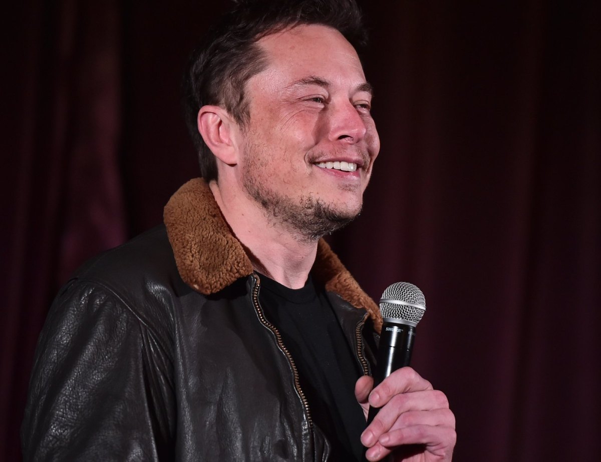 Elon Musk spricht am Mikrofon.