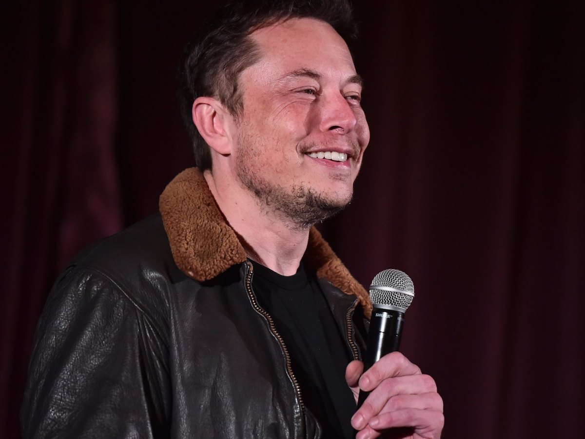 Elon Musk spricht am Mikrofon.