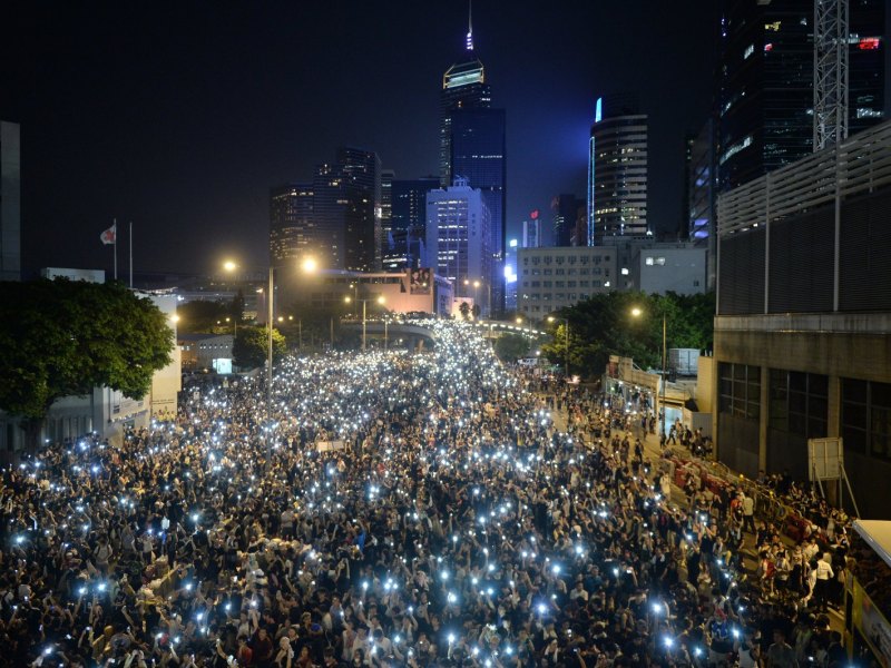 Eine Menschenmenge hält ihre Smartphones mit eingeschalteten Lichtern hoch.