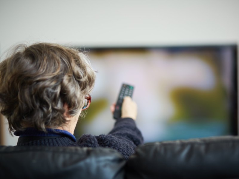 Mann sitzt vor einem Fernseher