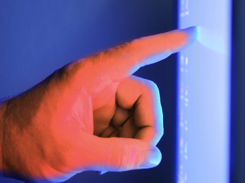 Ein Finger berührt einen Computerbildschirm.