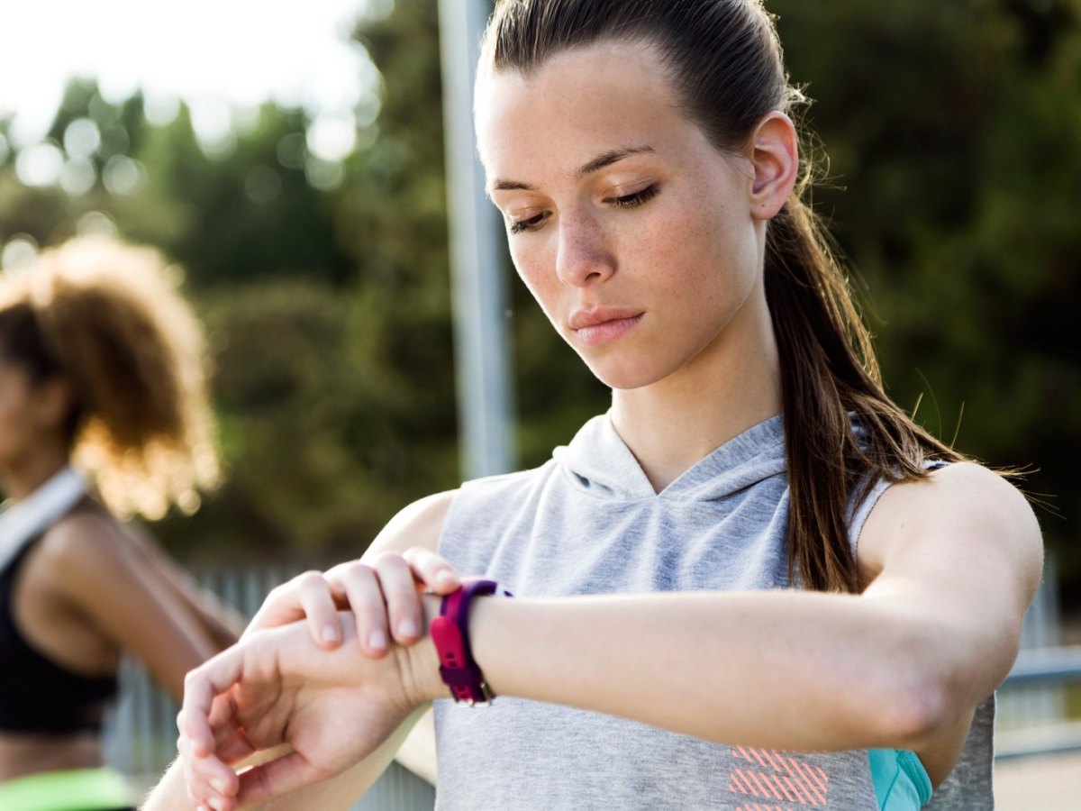 Frau mit Fitness-Tracke am Arm.