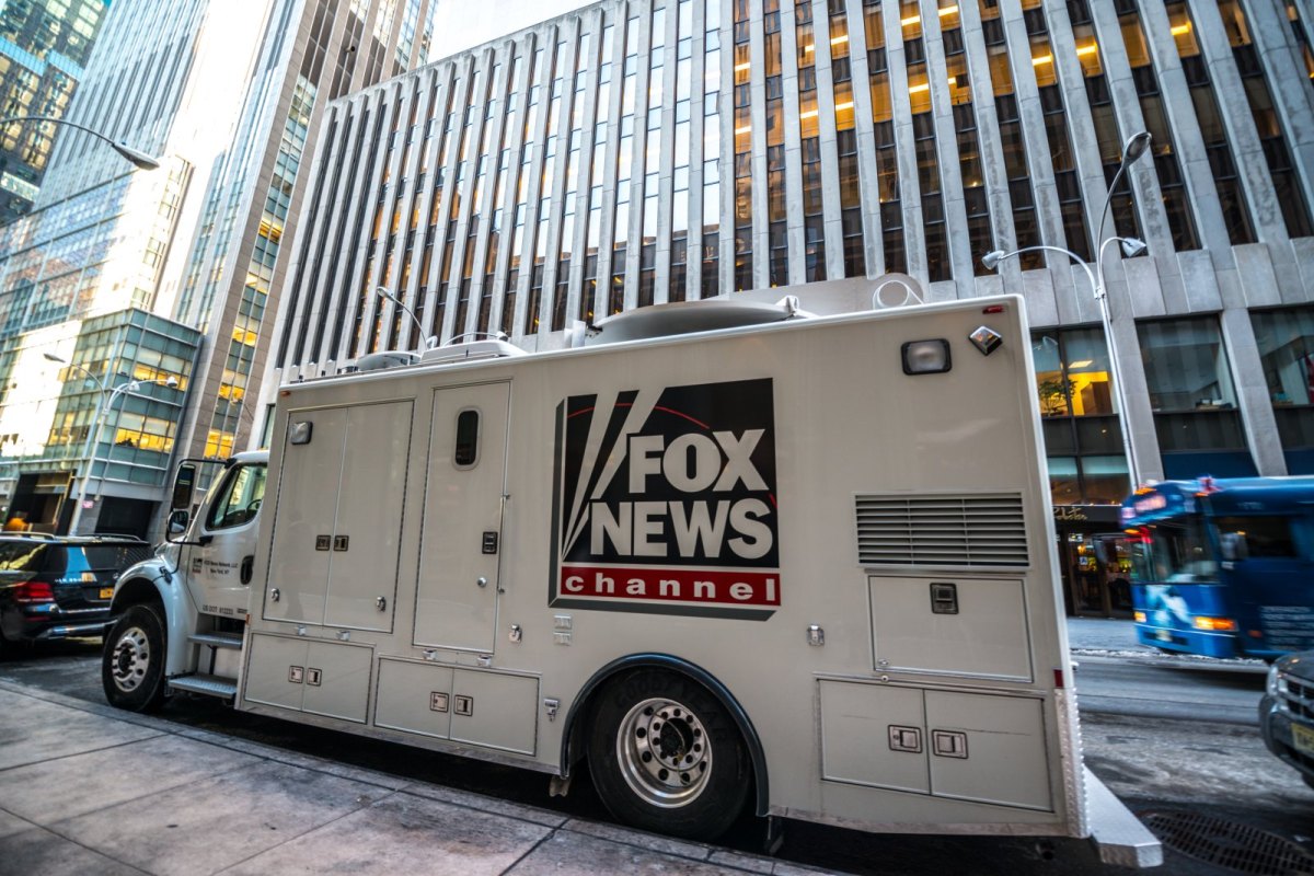 Fernsehertruck mit Fox News-Aufschrift vor einem Gebäude.