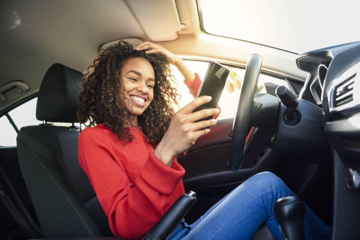 Frau mit Handy im Auto