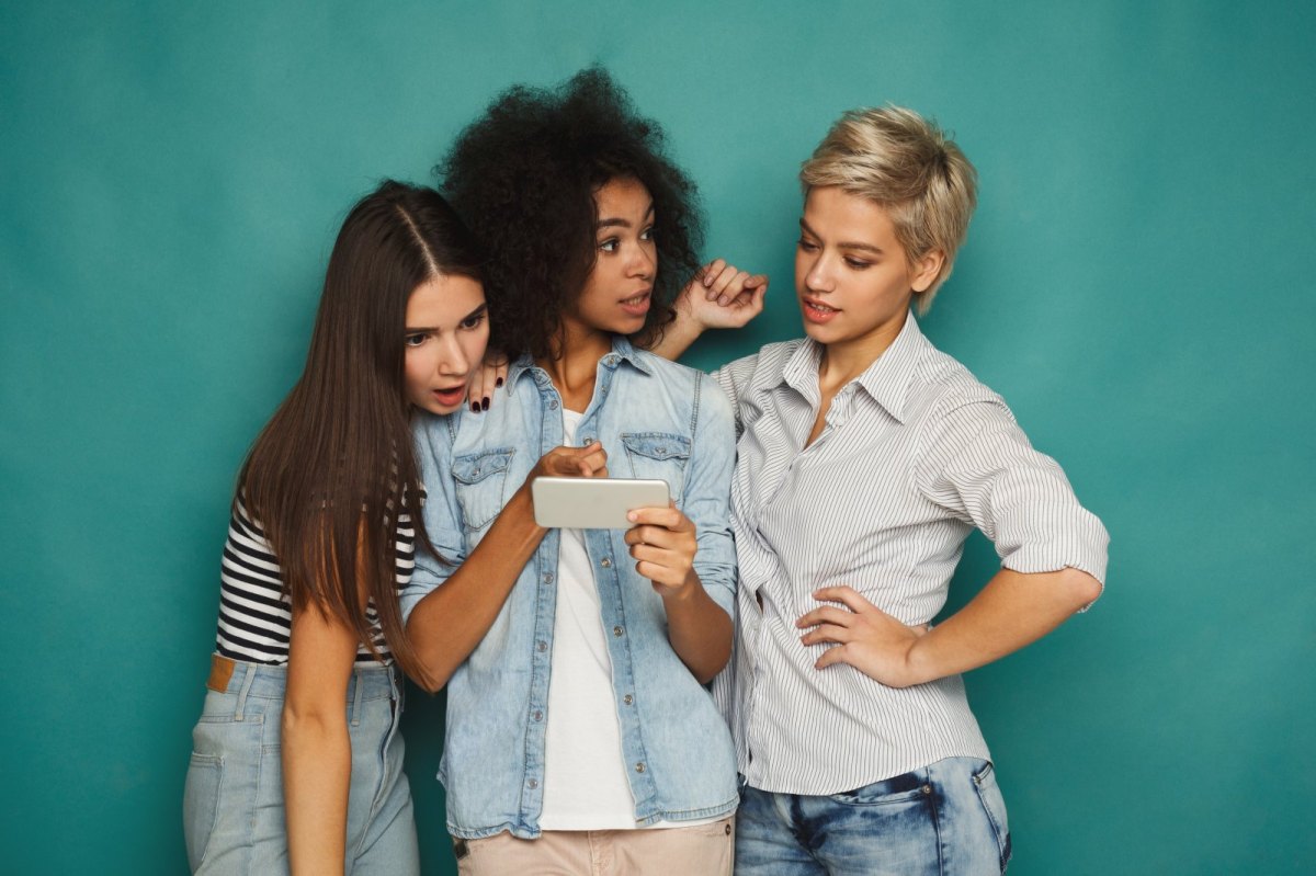 Drei Frauen gucken auf ein Smartphone.