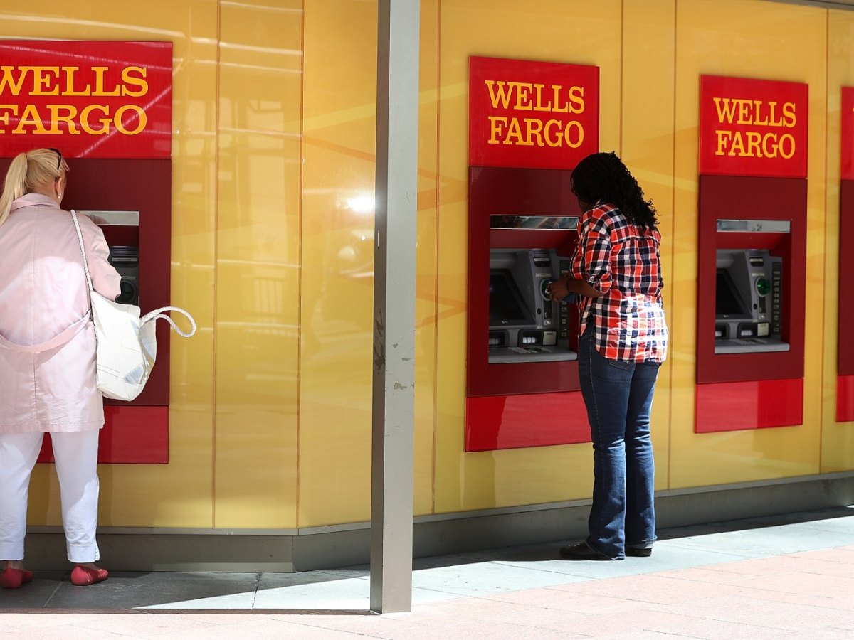 Zwei Frauen heben an zwei Bankautomaten Geld ab.