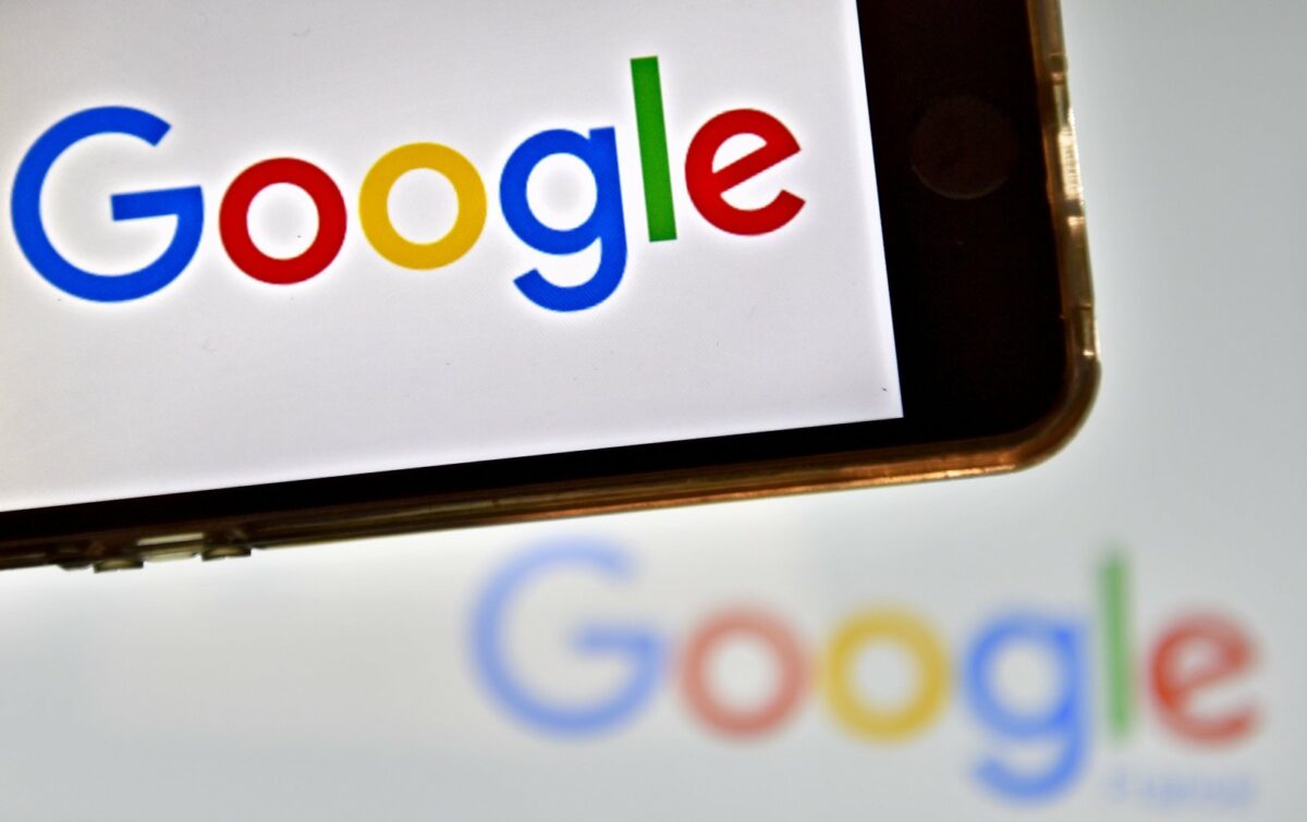Google-Logo auf Smartphone-Display und im Hintergrund