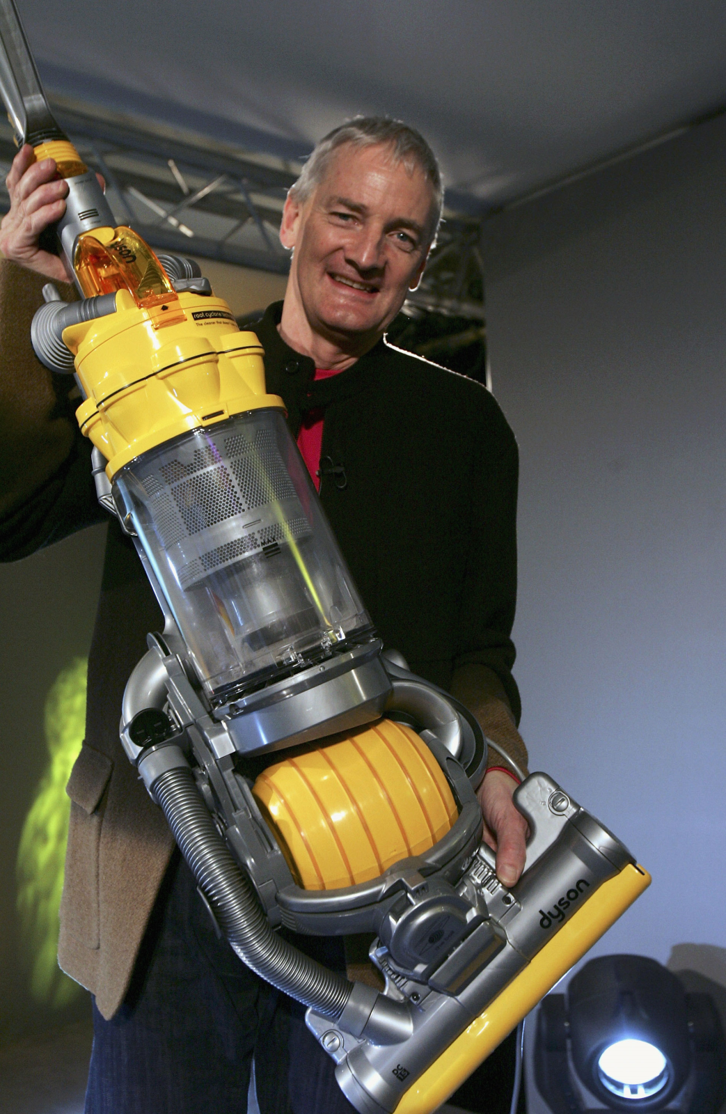 Dyson-Gründer James Dyson hält einen Dyson Staubsauger hoch