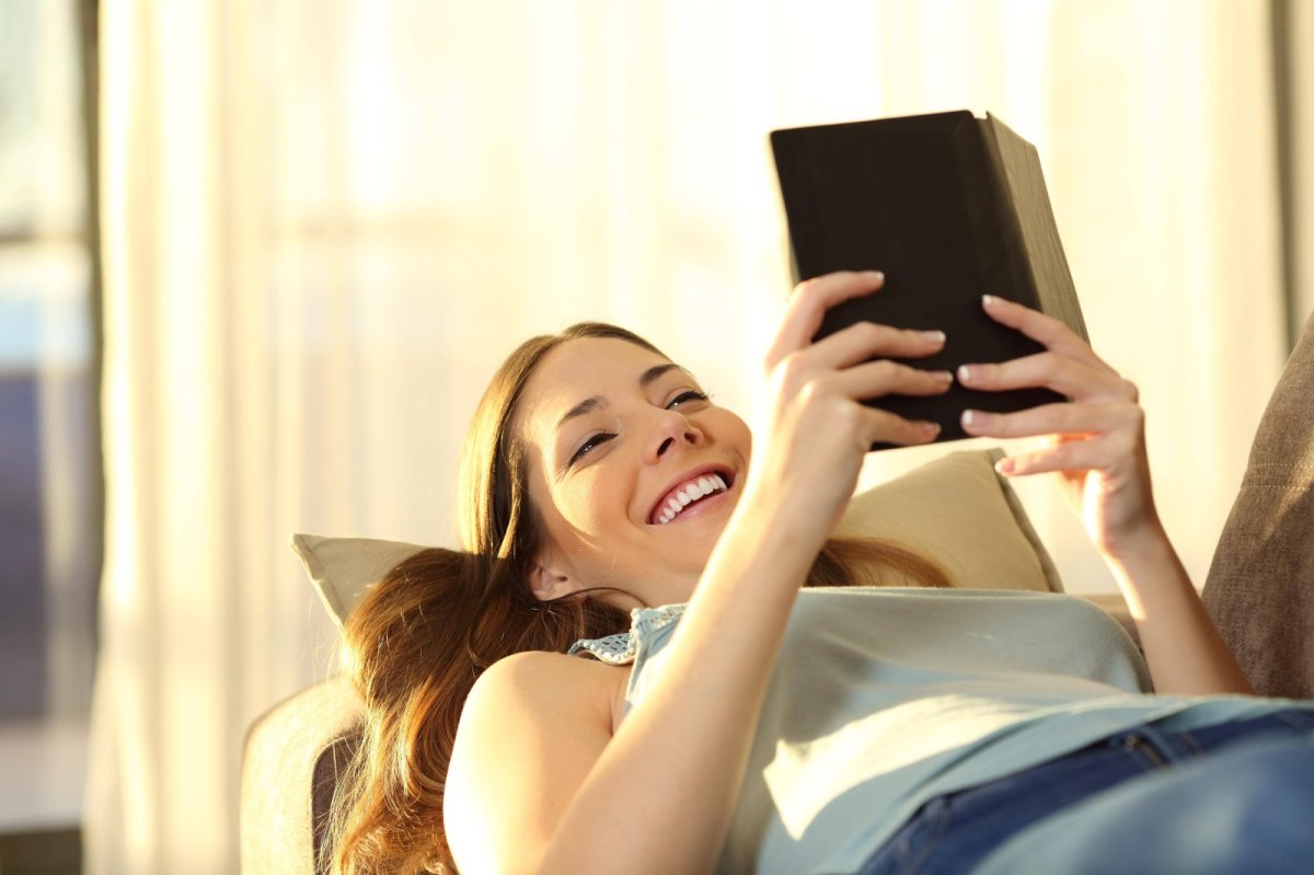 Frau liest auf einem E-Reader.