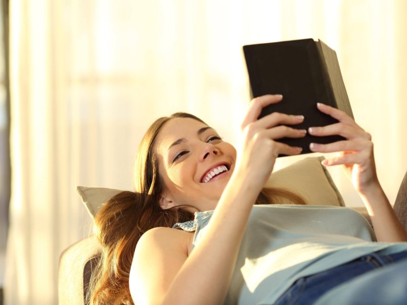 Frau liest auf einem E-Reader.