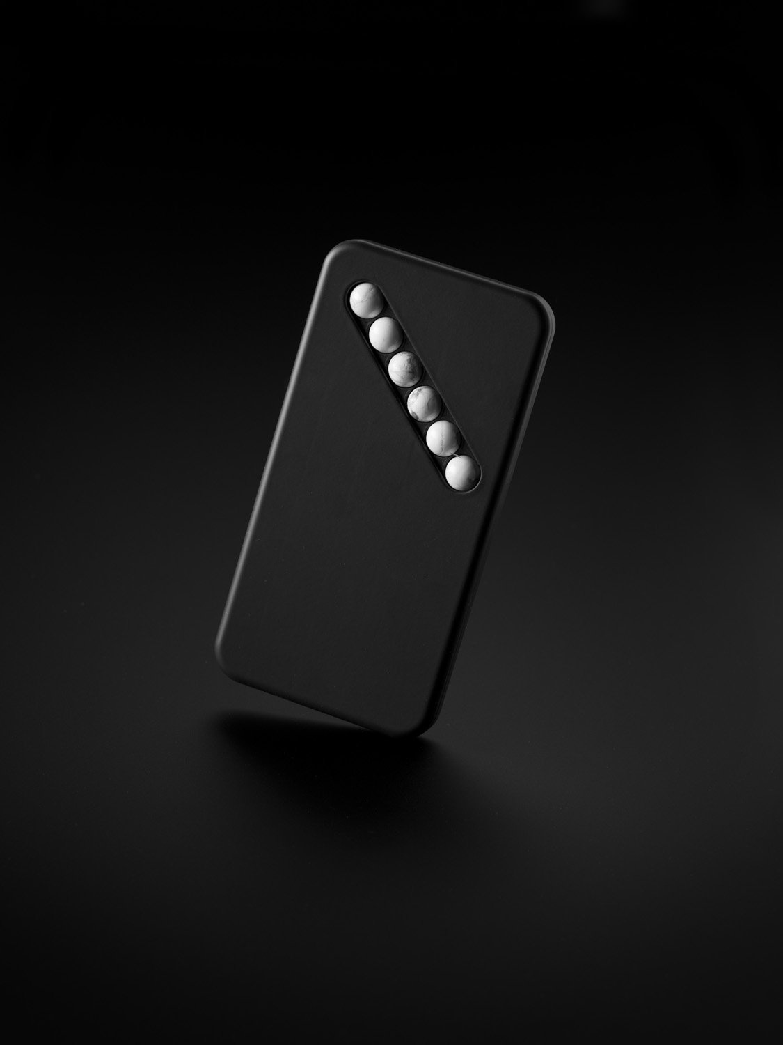 Das Ersatz-Smartphone vom Designer Klemens Schillinger ausgeleuchtet vor dunklem Hintergrund.