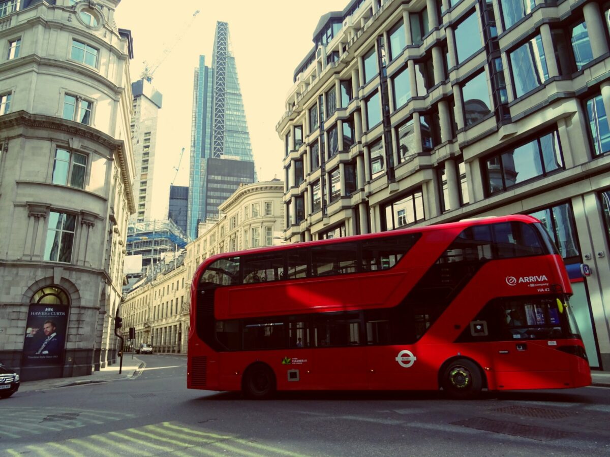Ein roter Bus fährt über eine Kreuzung in London.