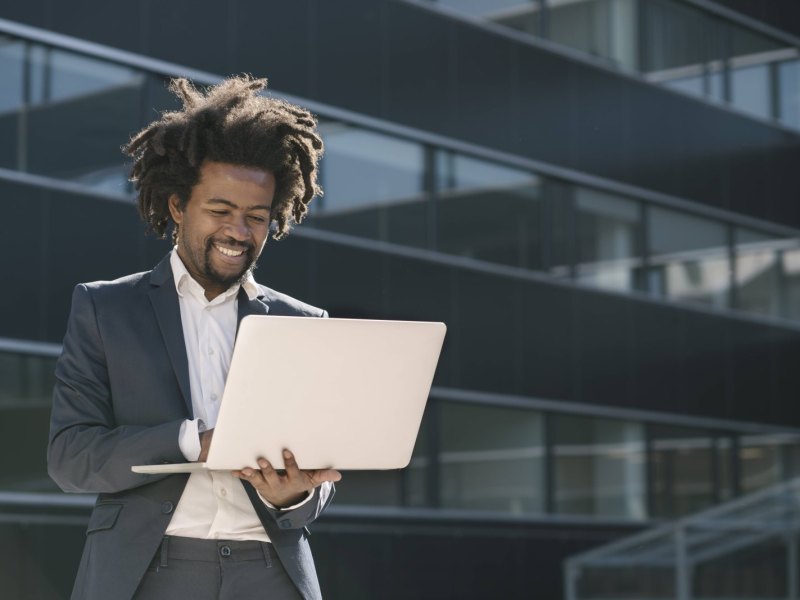 Mann mit Laptop in der Hand