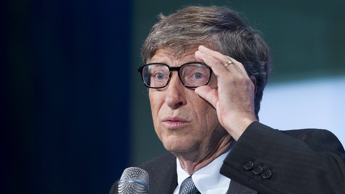 Bill Gates greift sich während eines Auftritts an die Brille.