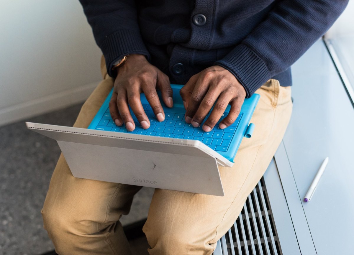 Mann tippt auf einem Microsoft Surface-Tablet.