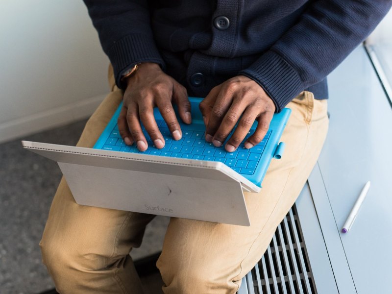 Mann tippt auf einem Microsoft Surface-Tablet.